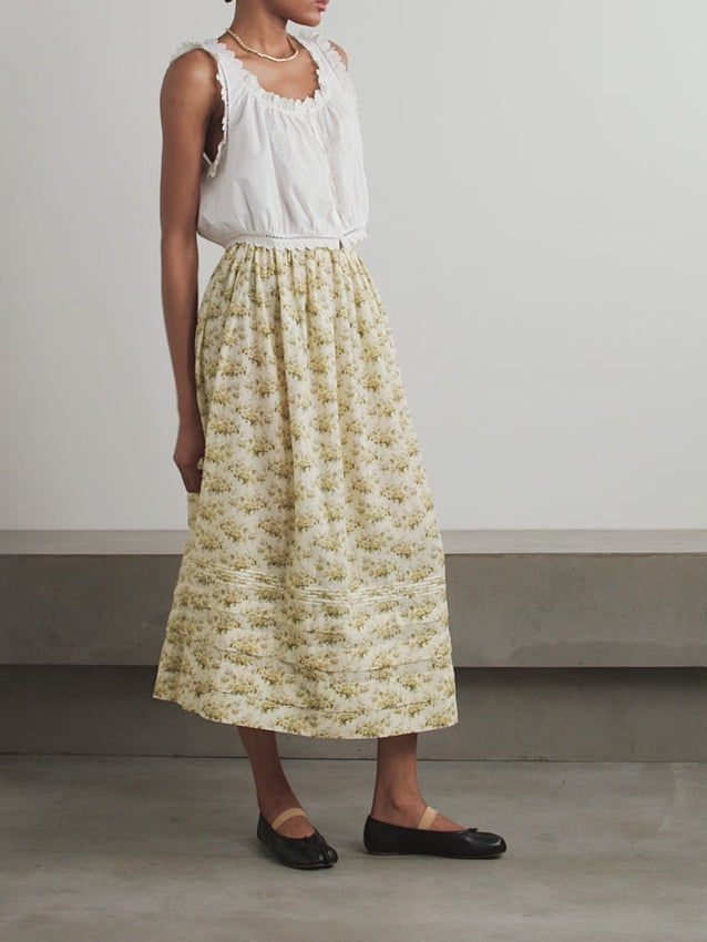 The Marcie skirt by DÔEN showcases a charming vintage-inspired floral print on breathable organic cotton-voile. Its tiered midi hemline adds structure and movement while ensuring comfort. Crafted with at least 50% lower-impact materials, this skirt combines sustainable design with timeless elegance, making it a conscientious choice for refined wardrobes.