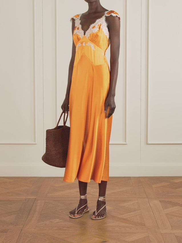Embrace timeless elegance with DÔEN's Fiona dress, where vintage romance meets modern sophistication. Crafted from sumptuous silk-satin in striking orange, this midi dress showcases creamy lace detailing at the plunging neckline and refined cap sleeves. The expertly bias-cut skirt cascades from the bodice in fluid, graceful folds that move with effortless elegance. An artisanal piece designed for those who appreciate romantic femininity and understated luxury.