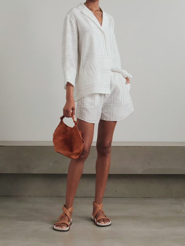 Discover effortless elegance with these embroidered organic cotton and silk-blend shorts. Crafted from a luxuriously soft, airy fabric blend, they feature an oversized monogram embroidery that makes a bold statement. The relaxed, pajama-inspired silhouette pairs comfort with contemporary style, while the elasticated waistband ensures a perfect fit for all-day wear. Ideal for lounging or casual outings, these shorts embody modern sophistication. 