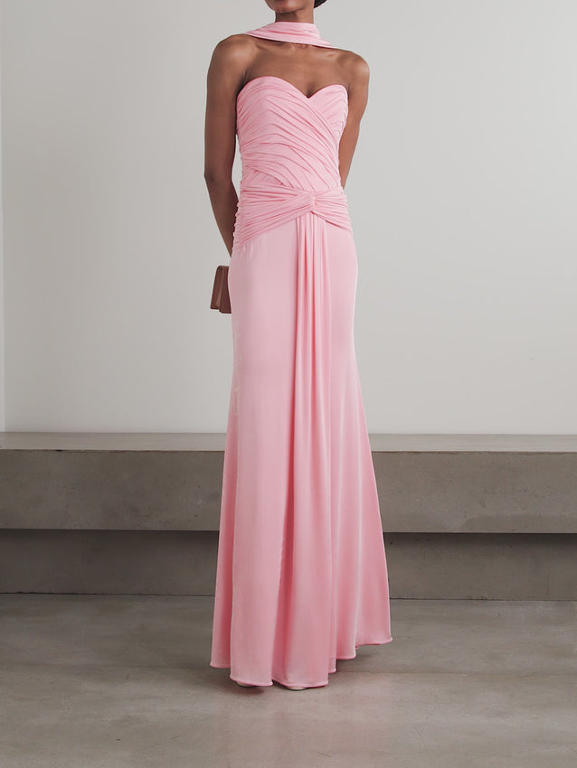 Discover refined sophistication with Ilkyaz Ozel's 'Amanda' gown, where graceful draping and thoughtful tailoring create an effortlessly polished silhouette. Crafted in fluid jersey, this piece features a distinctive scarf-detailed neckline and a sculptural pleated twist at the bodice, flowing seamlessly to an elegant floor-length hem. Pair with minimal accessories to let the gown's architectural beauty speak for itself.