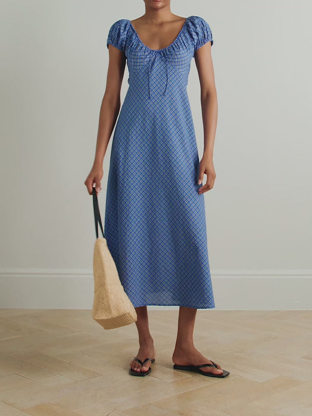 The Sofia dress channels vintage workwear charm through its timeless check pattern, crafted from breathable organic cotton-voile. Romantic puffed sleeves frame the shoulders while the fitted bodice creates a flattering silhouette that flows into a graceful bias-cut skirt. Layer with a delicate pendant to complete the look—perfect for effortless, elevated style.