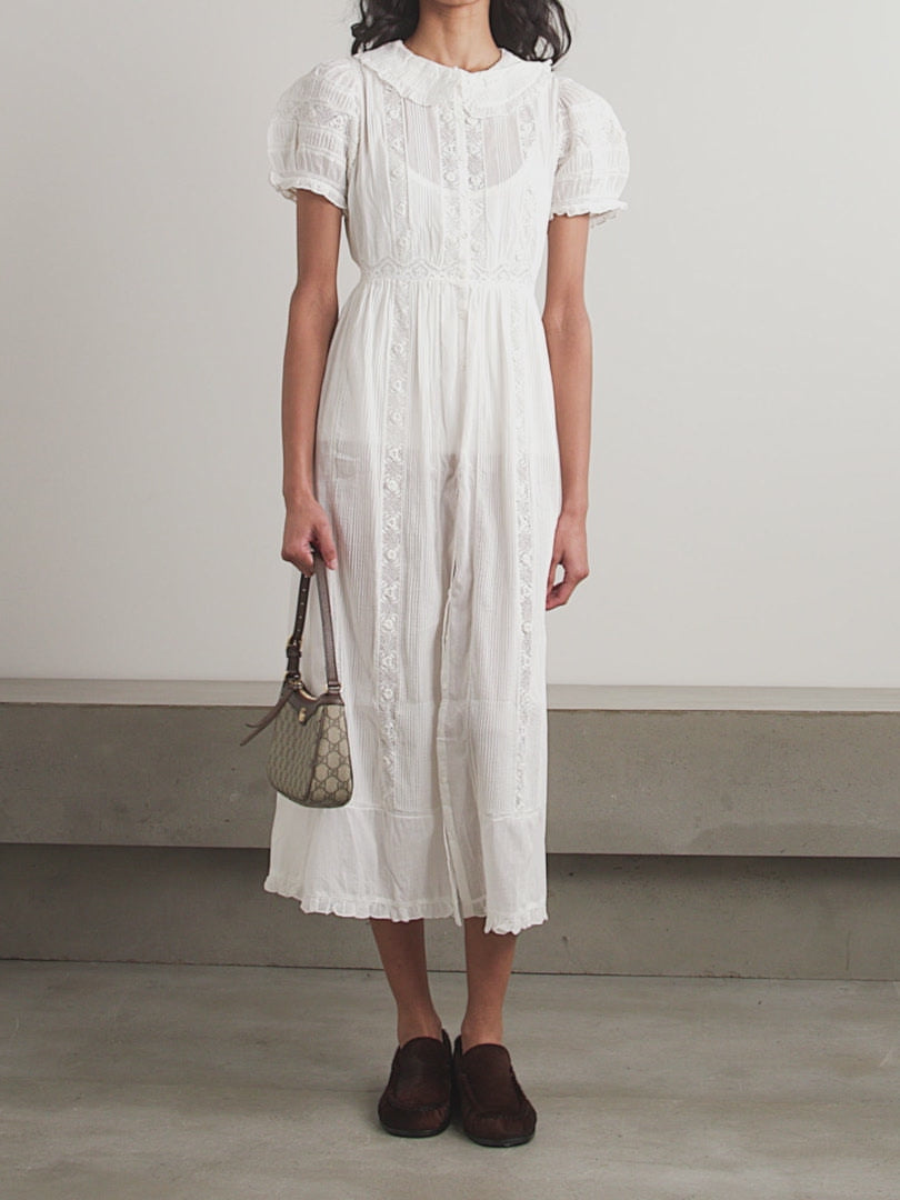 The Phoebe cotton-voile midi dress by DÔEN combines vintage charm with sustainable design. Crafted from organic cotton-voile, it features delicate lace trims and a classic Peter Pan collar. The dress gently cinches at the waist before flowing into a soft, floaty skirt, complemented by subtly puffed sleeves. This piece offers a refined, romantic silhouette ideal for those seeking timeless elegance with eco-conscious materials.