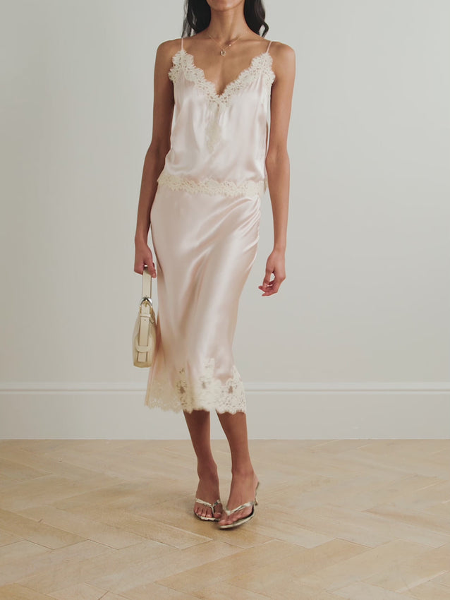 Elevate your wardrobe with the Elowena midi skirt by Doen, a refined piece that seamlessly blends timeless elegance with contemporary style. Crafted from luxurious silk, this skirt drapes beautifully while maintaining its shape throughout the day. Delicate lace trimming adds an understated romantic touch, making it perfect for both professional settings and special occasions. The midi length offers versatility and sophistication, pairing effortlessly with everything from tailored blouses to cashmere sweater