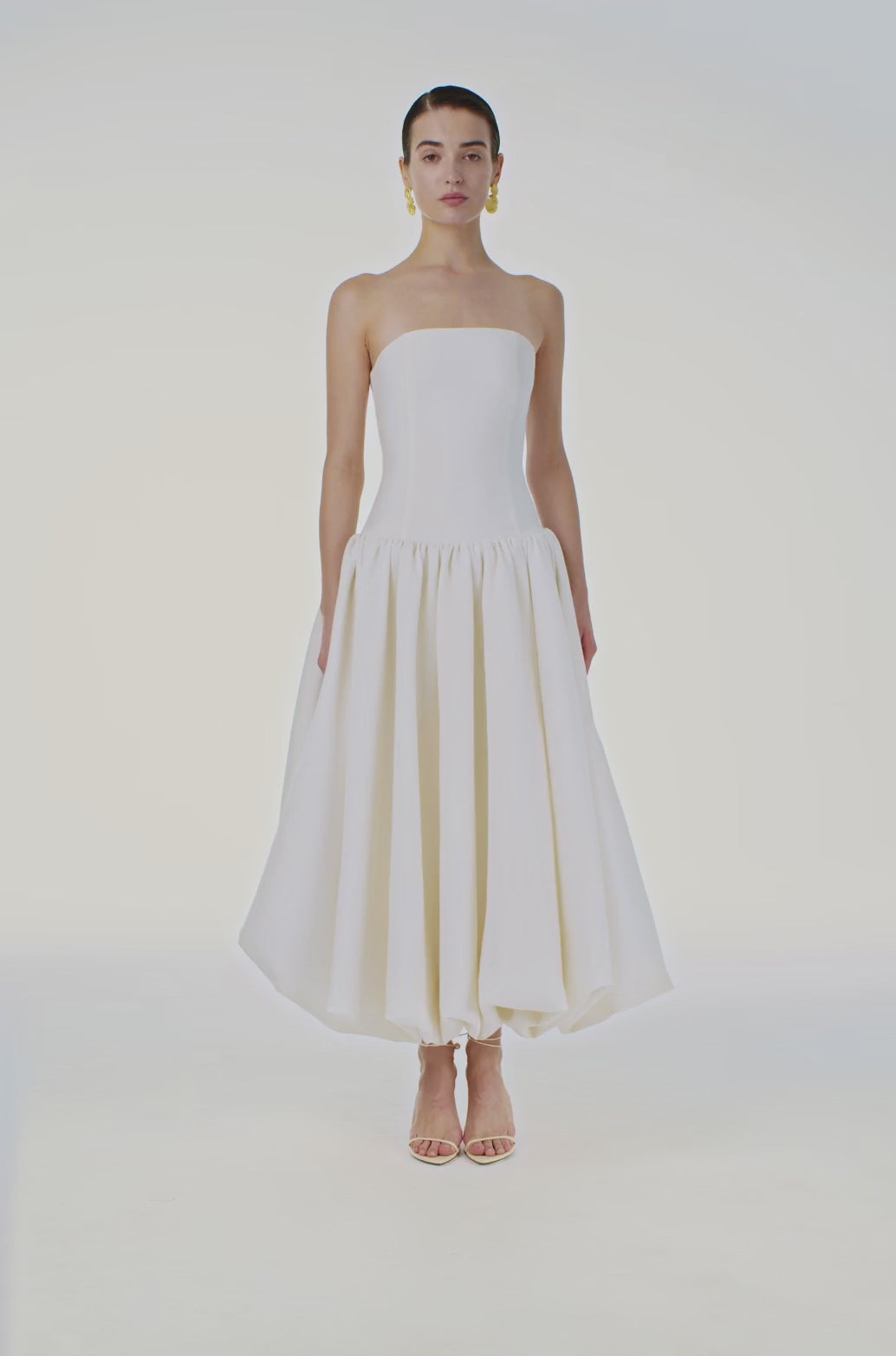 The Opera Gown combines classic elegance with contemporary design, featuring a strapless solid bodice and a high-waisted, pleated A-line skirt that flatters the figure. Its sleeveless construction offers both comfort and style, making it an excellent choice for summer occasions and formal events. This gown seamlessly blends sophistication with ease, providing a refined yet effortless look for warm-weather gatherings.