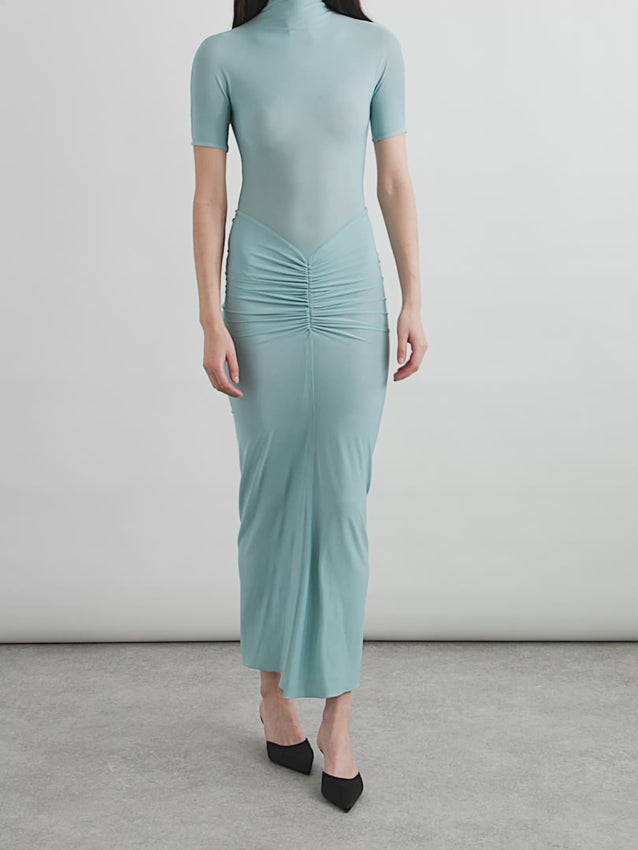 Discover the essence of modern femininity with this striking midi dress. Crafted from luxurious stretch-jersey, the design features a sculpted bodice that hugs your silhouette, flowing into elegant ruching below the waist. This thoughtfully constructed piece celebrates body consciousness through its architectural tailoring, creating a flattering shape that honors the natural contours of the female form. Perfect for those who appreciate fashion that combines sophistication with intentional design.