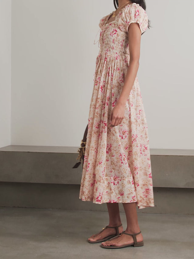 Inspired by vintage charm, the Stanza Midi Dress captures nostalgic elegance in certified organic cotton-voile. Whimsical floral patterns dance across the fabric, complemented by delicate lace trim that adds romantic detail. The fitted silhouette cinches gracefully under the bust before flowing into a loosely gathered waist, creating a flattering and effortless silhouette perfect for warm days and special occasions.