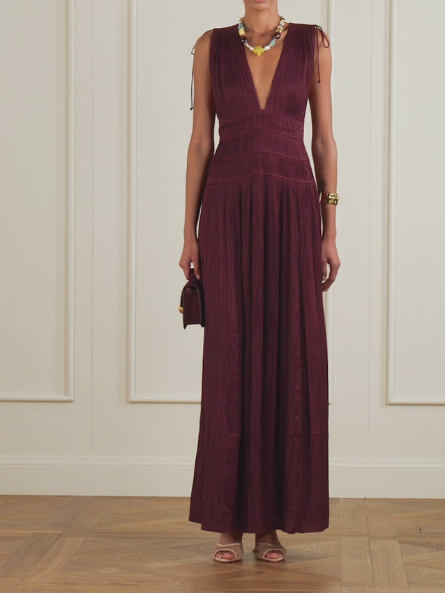 The Tasneem gown embodies timeless elegance with its delicate plissé-satin construction. Expertly gathered through the body, it features a striking deep neckline and a flowing skirt designed to move with graceful fluidity. The rich Claret shade pairs beautifully with gold or silver jewelry, making it an ideal choice for evening occasions and special events. A sophisticated piece that transcends seasonal trends.