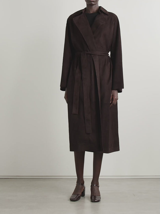 Elevate your outerwear with The Row's Solana suede trench coat, a masterpiece of Italian craftsmanship. Rendered in sumptuous suede, this coat features a relaxed silhouette balanced by a defining waist belt that creates an effortlessly refined silhouette. A timeless investment piece that seamlessly transitions from season to season, bringing understated luxury to any ensemble.