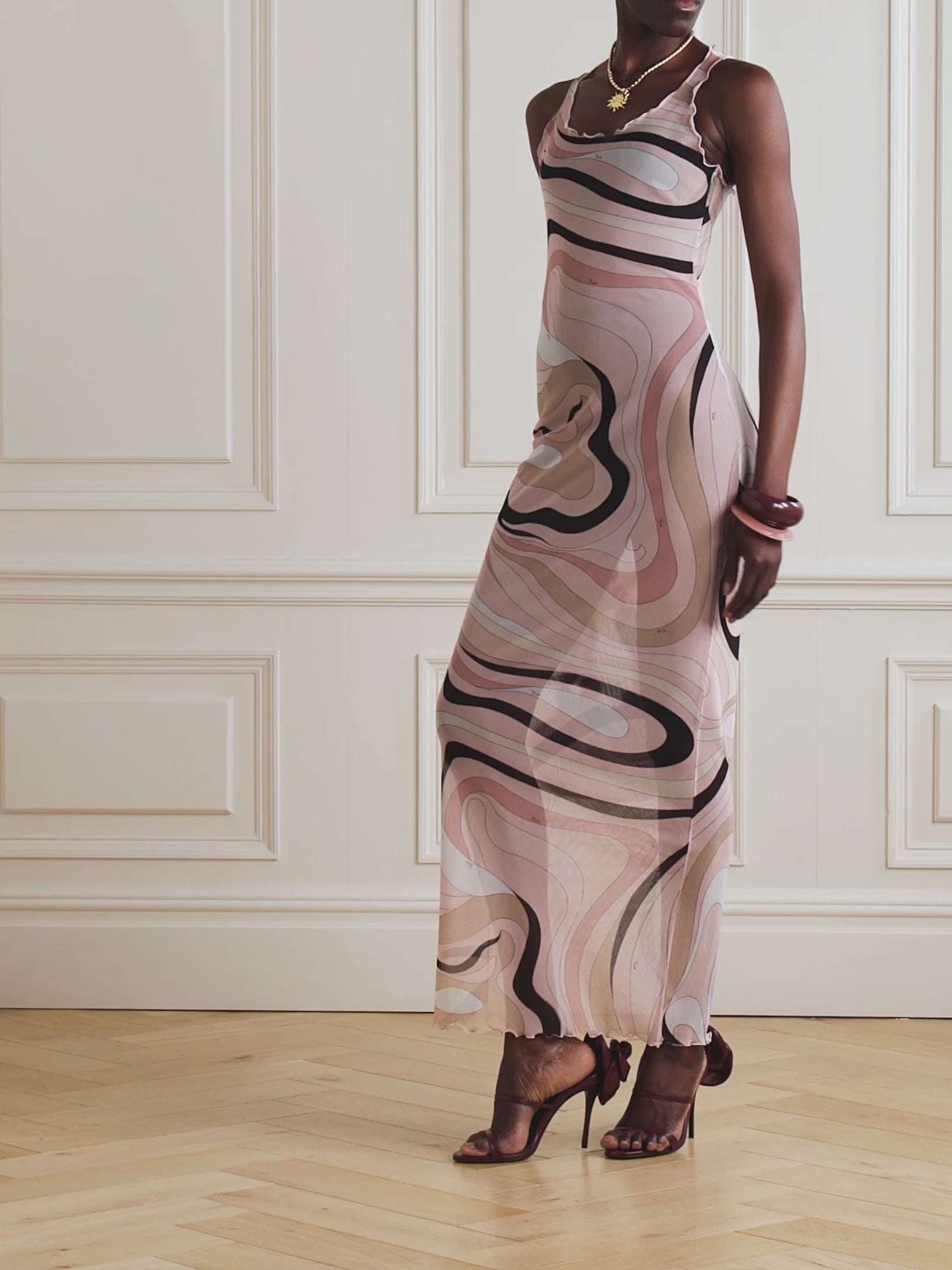 The Marmo Tulle Dress by PUCCI features sheer mesh fabric accented with delicate ruffled trims, showcasing the iconic marbled 'Marmo' motif from 1968. Designed for a body-hugging silhouette, it offers versatility—wear it over tonal underlayers for a chic look or as a stylish coverup for beach and boat outings.