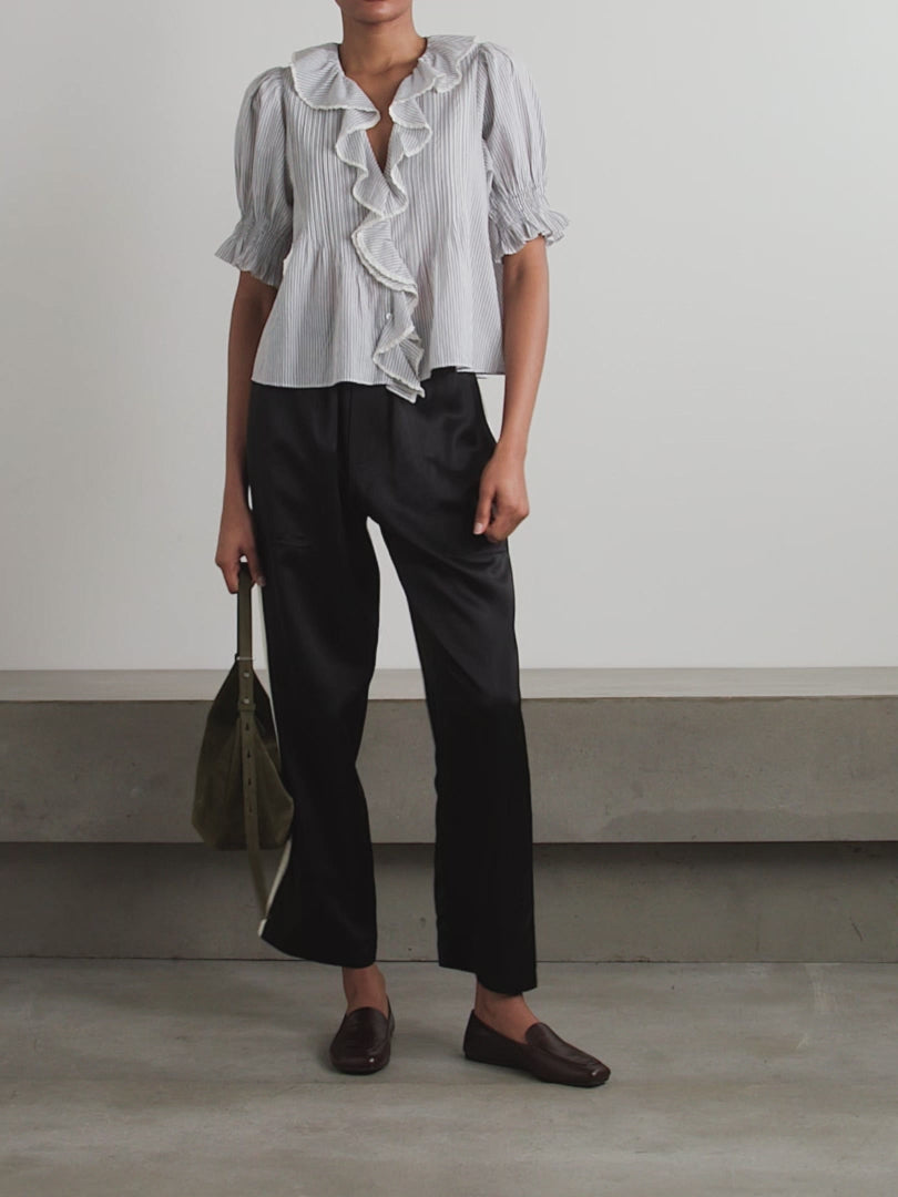 DÔEN's Henri top combines delicate detailing with sustainable craftsmanship. Crafted from organic striped cotton-voile, free from harmful pesticides, it features smocked puffed sleeves and lace-trimmed ruffles that frame the neckline. This top offers a refined, airy silhouette perfect for pairing with straight-leg jeans, balancing comfort with a sophisticated, vintage-inspired aesthetic.