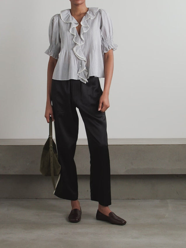 DÔEN's Henri top combines delicate detailing with sustainable craftsmanship. Crafted from organic striped cotton-voile, free from harmful pesticides, it features smocked puffed sleeves and lace-trimmed ruffles that frame the neckline. This top offers a refined, airy silhouette perfect for pairing with straight-leg jeans, balancing comfort with a sophisticated, vintage-inspired aesthetic.